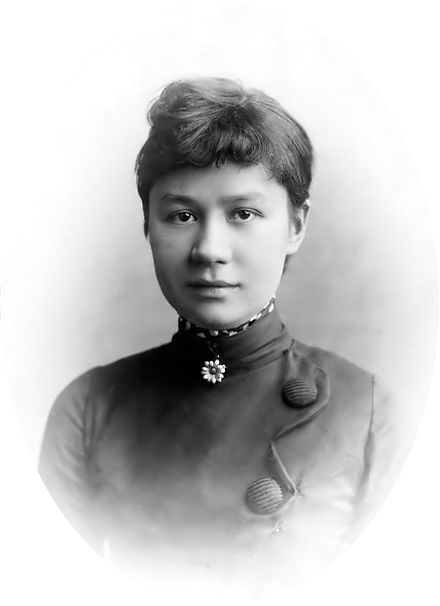 black and white picture, of Joanna van Gogh, Theo van Gogh's wife. She has dark hair in a bun, and is wearing a dark dress with bottons in the front.